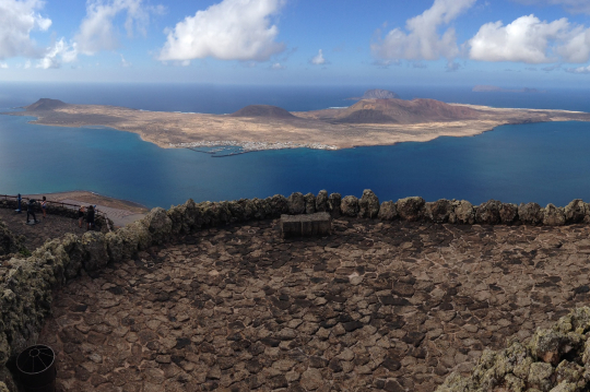 Blick von einem Berg über das Meer auf eine kleine vorgelagerte Insel auf Lanzarote